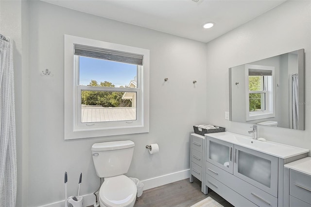 bathroom with vanity, toilet, and hardwood / wood-style flooring