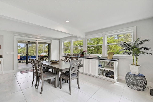 tiled dining room featuring a wealth of natural light and beam ceiling