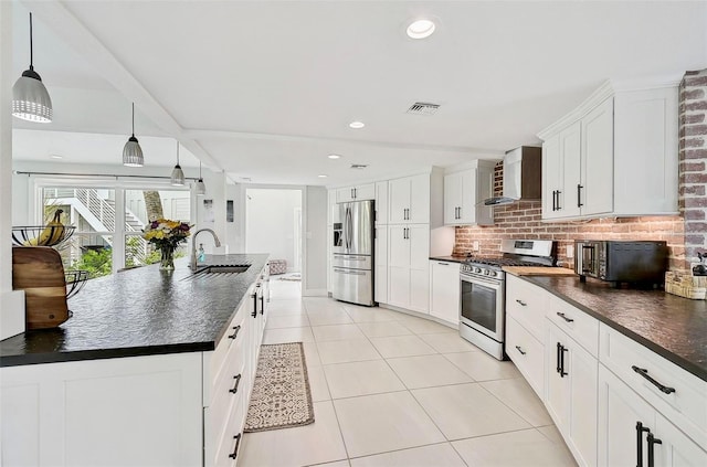 kitchen featuring decorative light fixtures, wall chimney exhaust hood, stainless steel appliances, sink, and white cabinets