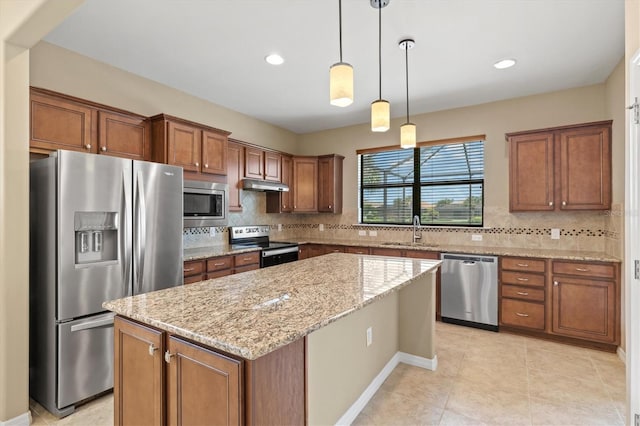 kitchen featuring light stone countertops, sink, decorative backsplash, a kitchen island, and appliances with stainless steel finishes