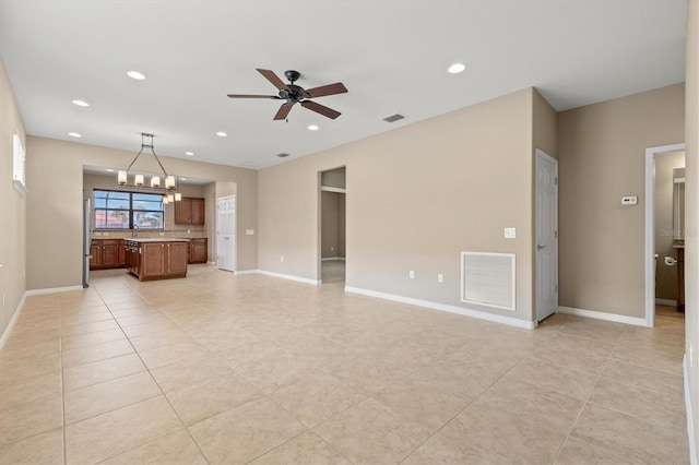 unfurnished living room with ceiling fan with notable chandelier and light tile patterned flooring