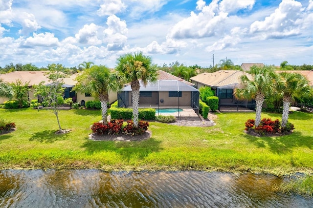 back of property featuring a lanai, a lawn, and a water view