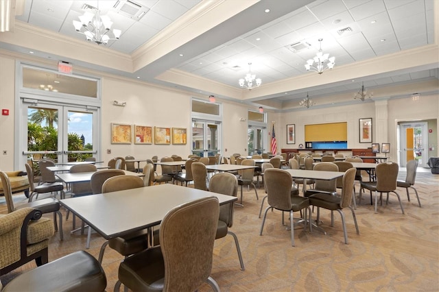 carpeted dining space with french doors and crown molding