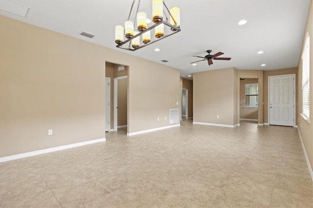 spare room featuring ceiling fan with notable chandelier