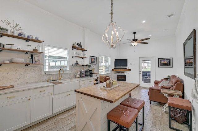 kitchen featuring a breakfast bar area, wood counters, white cabinetry, and light hardwood / wood-style floors