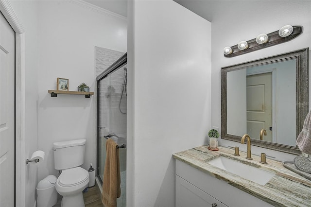 bathroom with toilet, a shower with door, and vanity