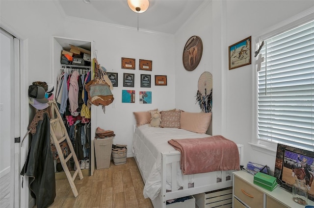 bedroom with crown molding, a closet, multiple windows, and light hardwood / wood-style floors