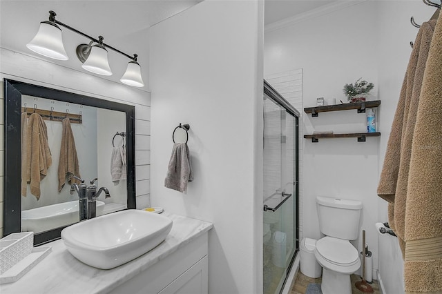 bathroom with ornamental molding, vanity, toilet, and a shower with door