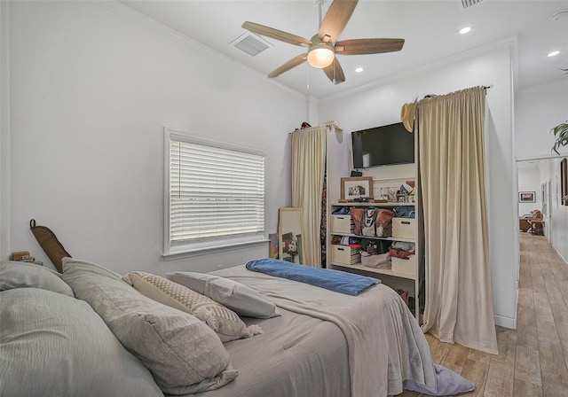 bedroom featuring crown molding, light hardwood / wood-style flooring, and ceiling fan