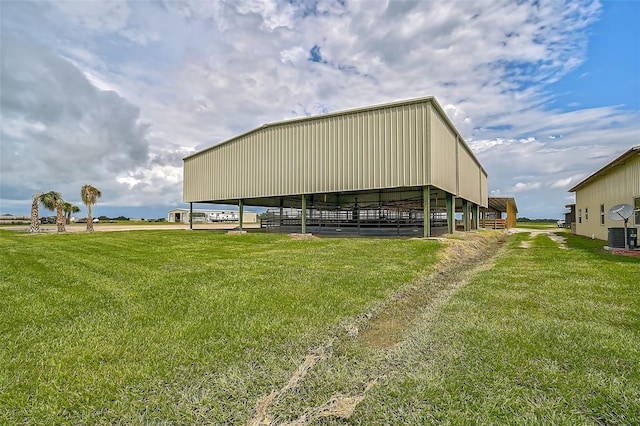 view of outdoor structure featuring a lawn and central AC unit