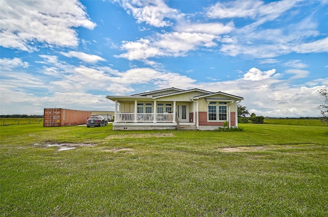 view of front of property with a porch, a rural view, and a front lawn