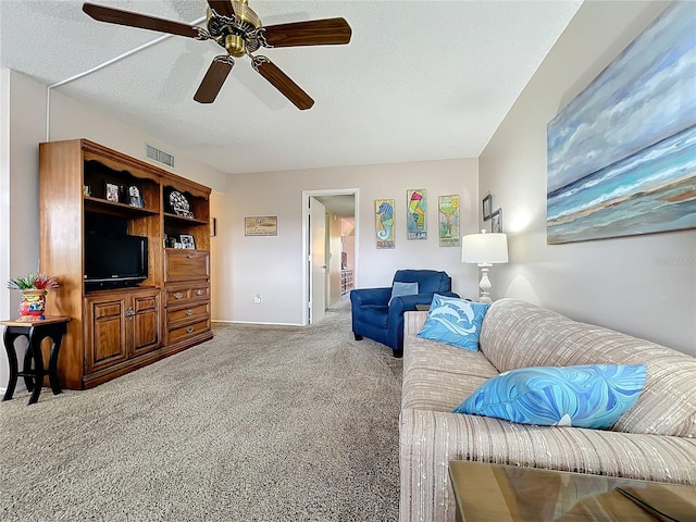 carpeted living room with a textured ceiling and ceiling fan