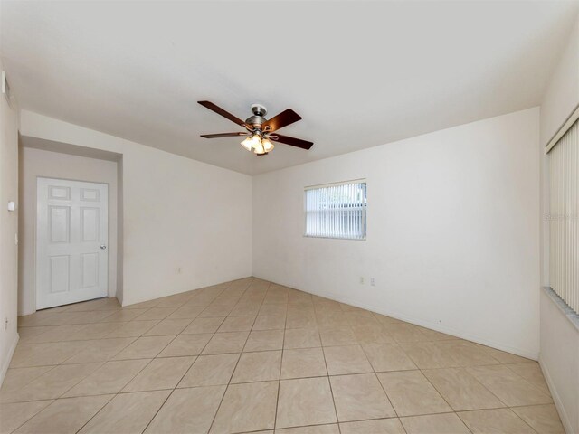 tiled spare room featuring ceiling fan