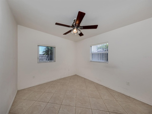 spare room with ceiling fan, light tile patterned flooring, and vaulted ceiling