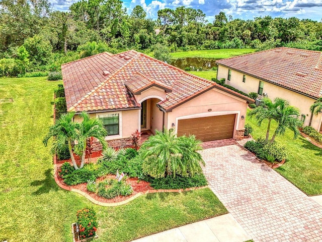 mediterranean / spanish home with a garage and a front lawn