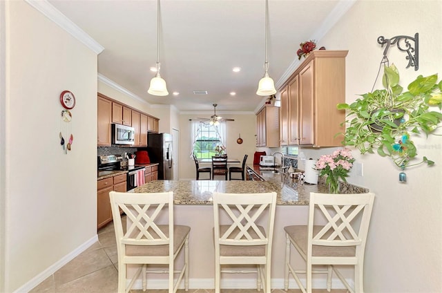 kitchen featuring appliances with stainless steel finishes, kitchen peninsula, a breakfast bar area, and hanging light fixtures