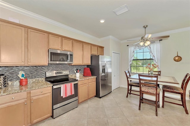 kitchen with light stone countertops, light tile patterned floors, stainless steel appliances, ornamental molding, and ceiling fan