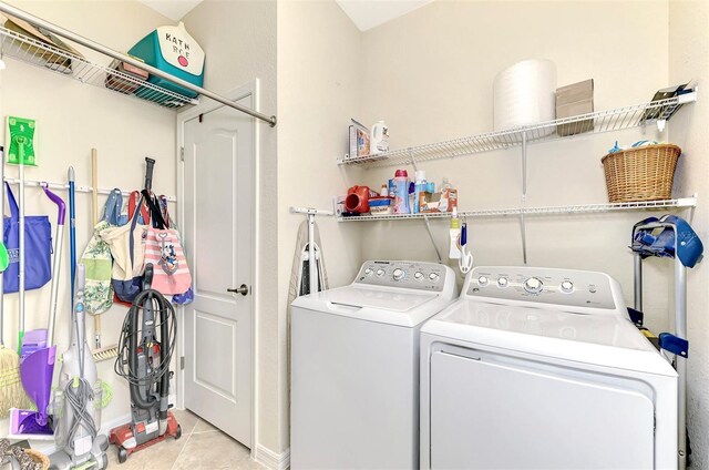 laundry area featuring washing machine and dryer and light tile patterned floors