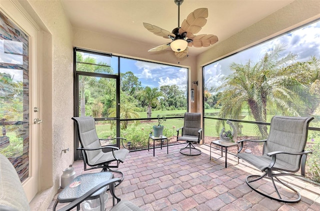 unfurnished sunroom featuring ceiling fan