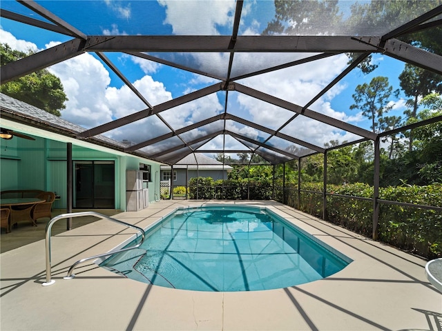 view of pool featuring glass enclosure and a patio area