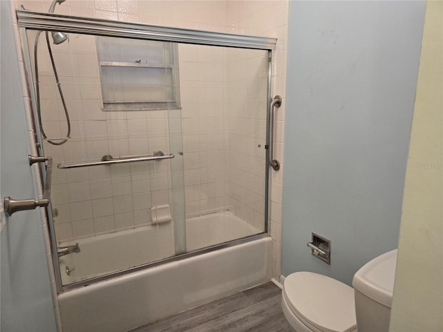 bathroom with shower / bath combination with glass door, toilet, baseboards, and wood finished floors