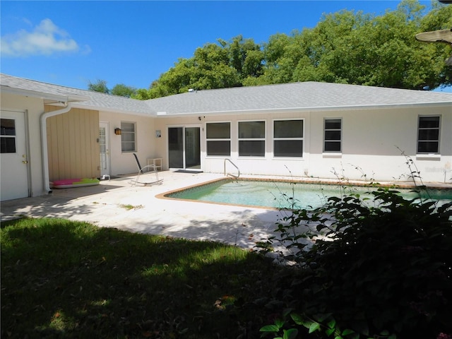 back of property with an outdoor pool, stucco siding, and a patio