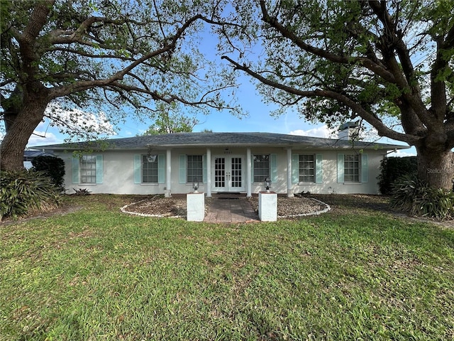 ranch-style house featuring a front lawn, french doors, and stucco siding