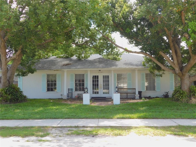 single story home featuring a front lawn, french doors, and stucco siding