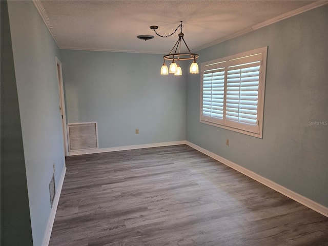 unfurnished room with baseboards, visible vents, an inviting chandelier, dark wood-style flooring, and crown molding