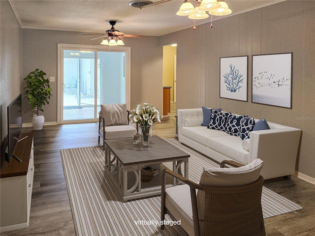 living room with ceiling fan, wood-type flooring, and ornamental molding