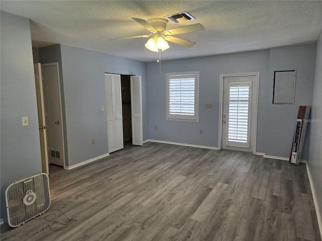 spare room with ceiling fan, dark wood-type flooring, and a textured ceiling