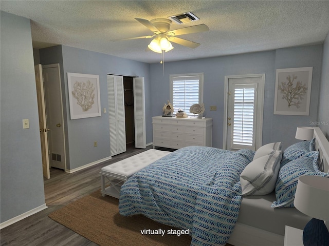 bedroom featuring a textured ceiling, ceiling fan, and dark hardwood / wood-style flooring