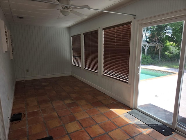 unfurnished sunroom with visible vents and ceiling fan