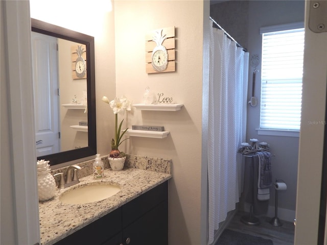 bathroom featuring walk in shower, a wealth of natural light, and vanity