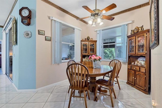 tiled dining space with ceiling fan and ornamental molding