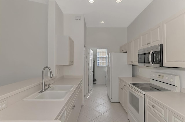 kitchen with sink, white appliances, white cabinetry, and light tile patterned flooring