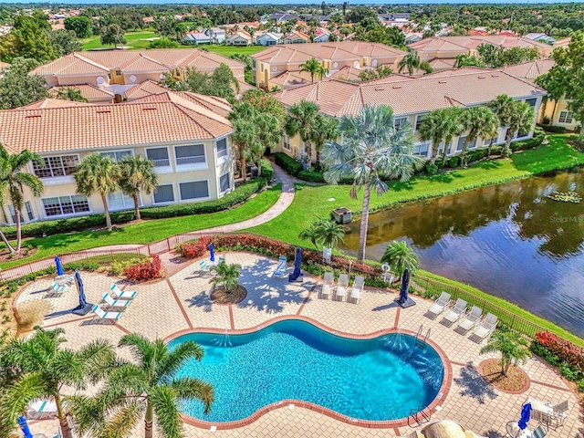 view of pool featuring a water view, a yard, and a patio area