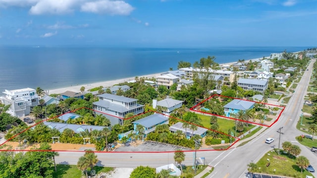 drone / aerial view featuring a water view and a beach view