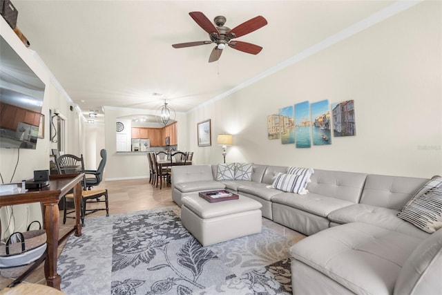 tiled living room featuring ceiling fan with notable chandelier and ornamental molding