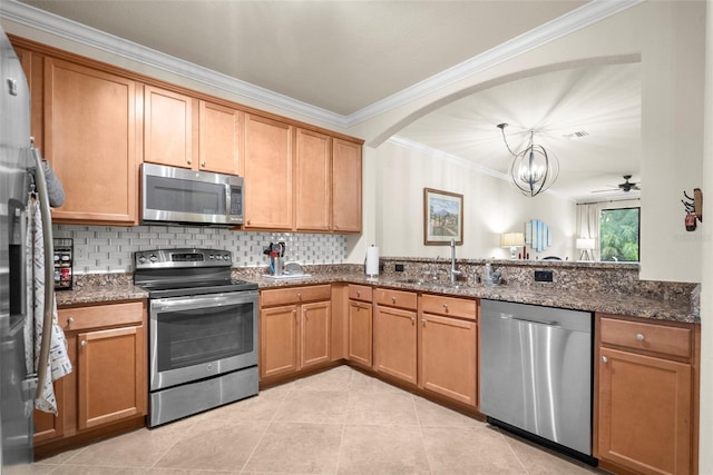 kitchen featuring light tile patterned floors, appliances with stainless steel finishes, sink, dark stone counters, and ornamental molding