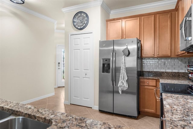 kitchen featuring appliances with stainless steel finishes, crown molding, decorative backsplash, dark stone counters, and light tile patterned flooring