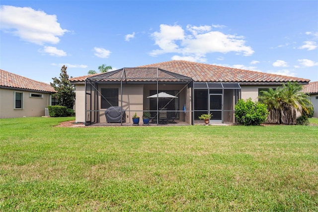 back of property featuring a lanai and a yard