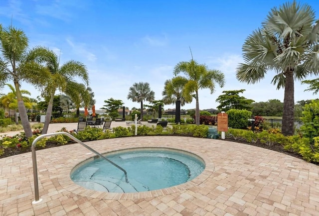 view of swimming pool featuring a community hot tub and a patio