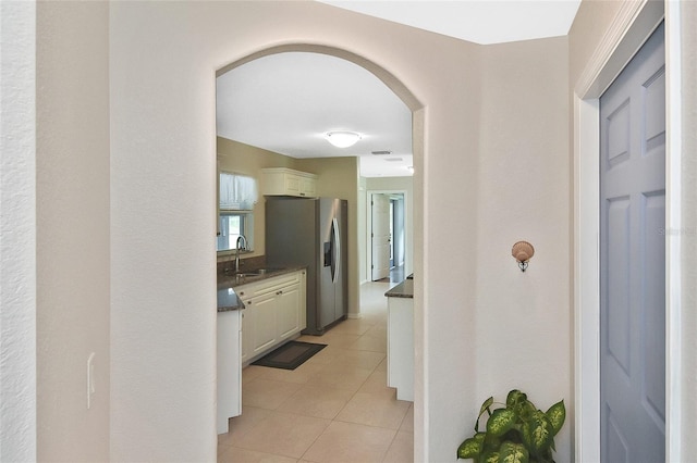 hall featuring light tile patterned floors and sink