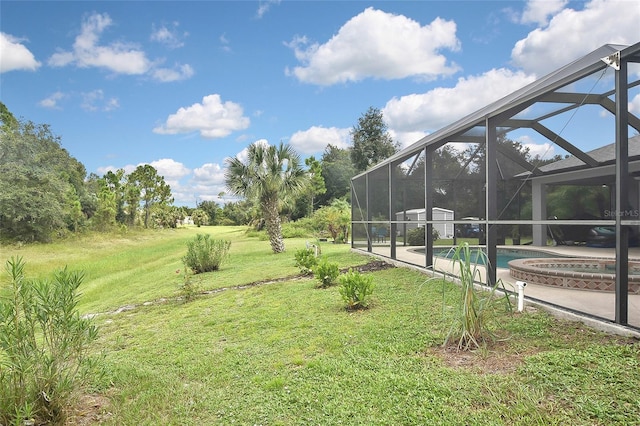 view of yard with glass enclosure and a swimming pool with hot tub