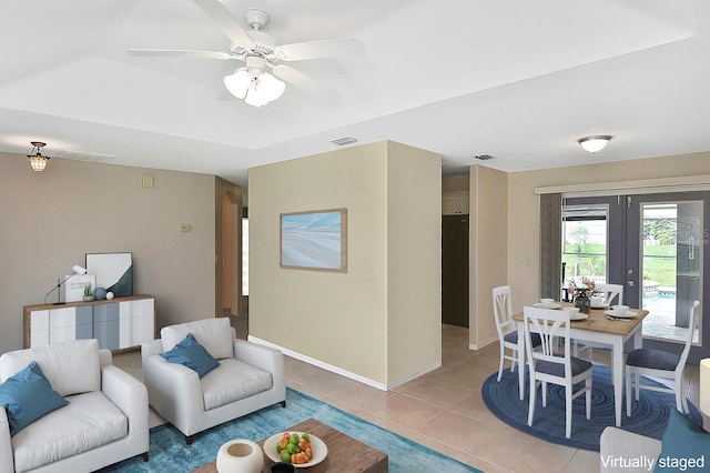 tiled living room featuring ceiling fan and french doors