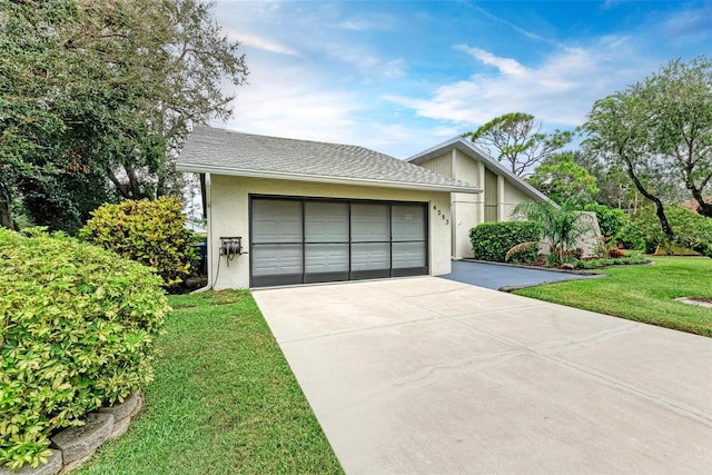 view of front of property featuring a front yard and a garage