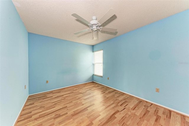 empty room featuring ceiling fan, light hardwood / wood-style floors, and a textured ceiling