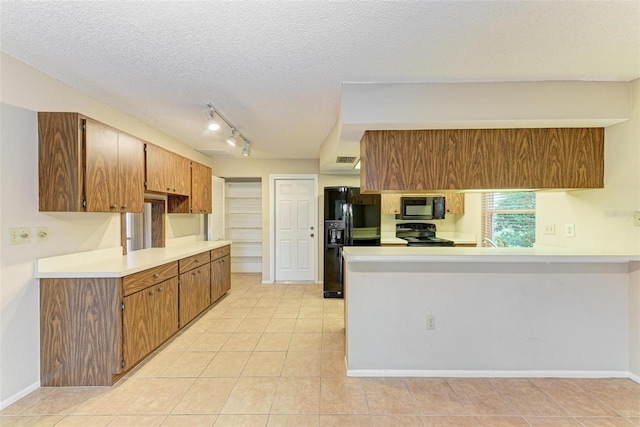 kitchen featuring light tile patterned flooring, a textured ceiling, and black appliances