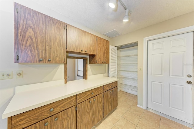 kitchen featuring light tile patterned flooring and a textured ceiling